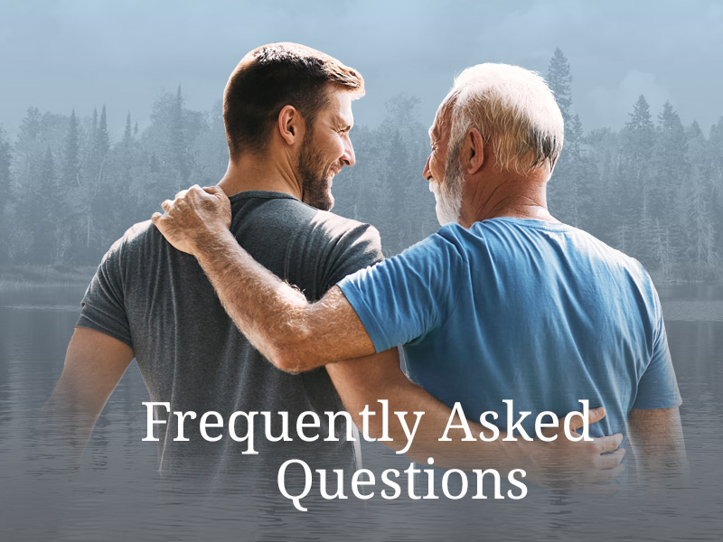 middle aged son and father enjoying time by a lake